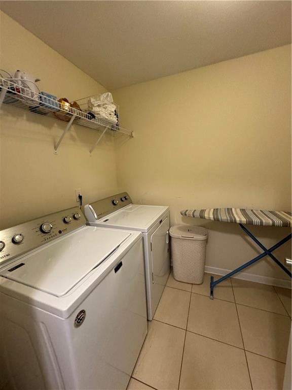 laundry room featuring light tile patterned floors and washer and clothes dryer