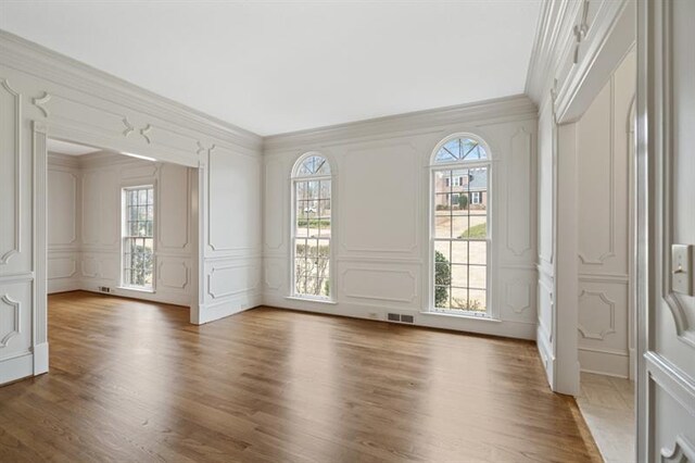 1585 Lazy River Ln, Sandy Springs, GA 30350 - unfurnished room with ornamental molding, wood finished floors, a wealth of natural light, and a decorative wall