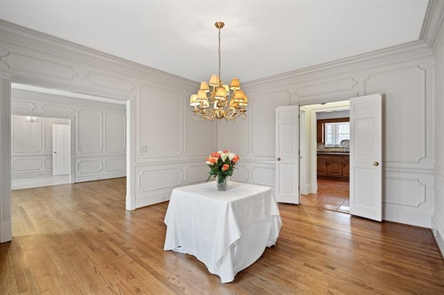 1585 Lazy River Ln, Sandy Springs, GA 30350 - dining area featuring ornamental molding, light wood finished floors, a decorative wall, and a chandelier