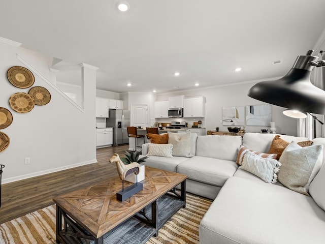 living room with recessed lighting, wood finished floors, crown molding, and baseboards