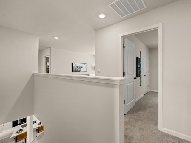 hall featuring an upstairs landing, carpet floors, baseboards, visible vents, and recessed lighting