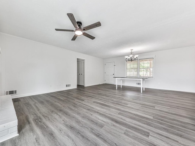 unfurnished living room featuring a chandelier, ceiling fan, wood finished floors, and baseboards
