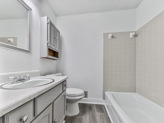 full bath with wood finished floors, toilet, vanity, and  shower combination