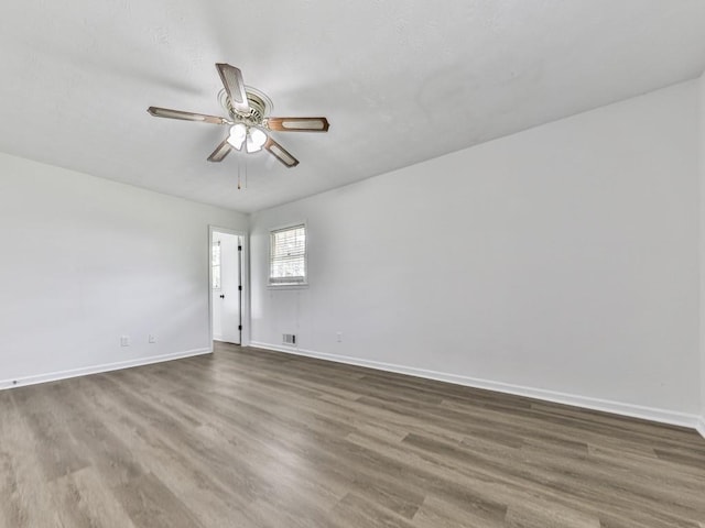 unfurnished room featuring baseboards, wood finished floors, and a ceiling fan
