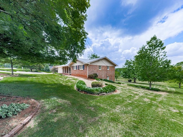 view of side of property featuring brick siding and a yard
