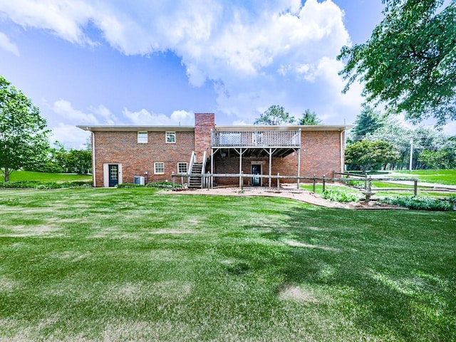 rear view of house with brick siding, a chimney, stairway, and a deck
