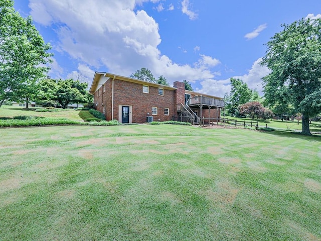 view of green lawn with stairs and a wooden deck