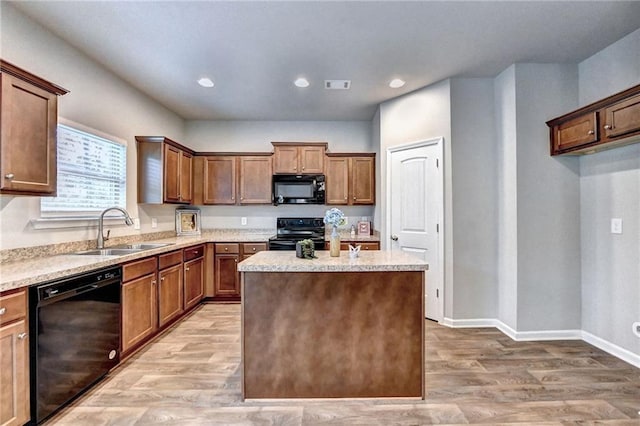 kitchen with hardwood / wood-style flooring, sink, black appliances, and a center island