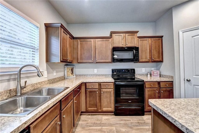 kitchen featuring light hardwood / wood-style floors, sink, and black appliances