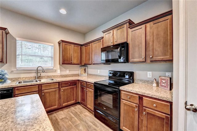 kitchen with sink, black appliances, and light wood-type flooring