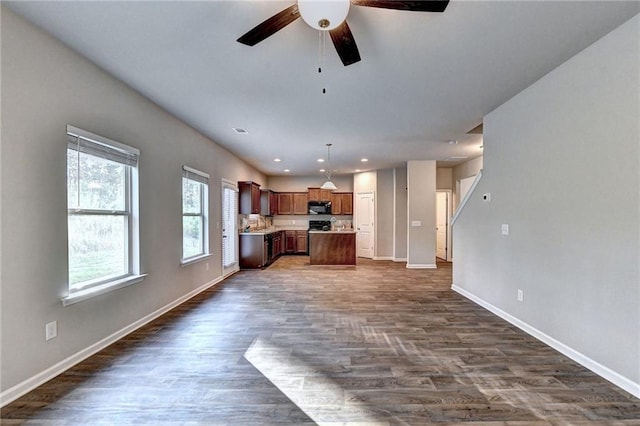 unfurnished living room featuring dark hardwood / wood-style floors and ceiling fan