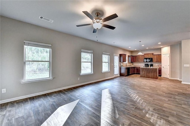 unfurnished living room with dark hardwood / wood-style floors and ceiling fan