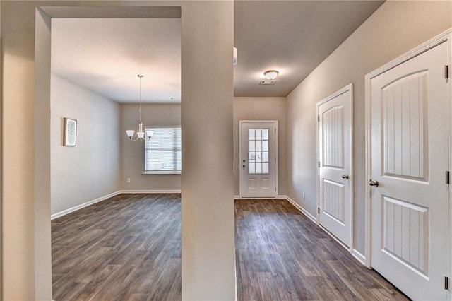 foyer entrance featuring plenty of natural light, a chandelier, and dark hardwood / wood-style flooring