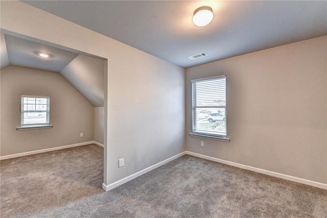 additional living space featuring carpet flooring and vaulted ceiling