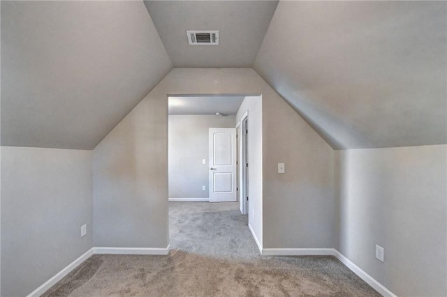 additional living space with light carpet and vaulted ceiling