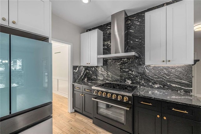 600 Oakmont Hl, Duluth, GA 30097 - kitchen featuring refrigerator, gas range oven, wall chimney range hood, dark stone countertops, and decorative backsplash