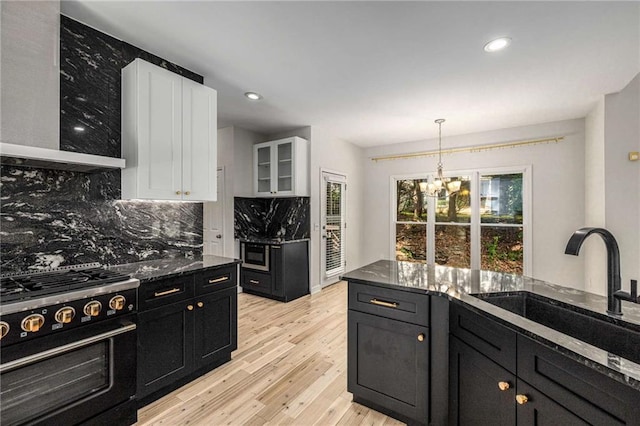 600 Oakmont Hl, Duluth, GA 30097 - kitchen with black stove, dark cabinets, white cabinetry, decorative backsplash, and a chandelier