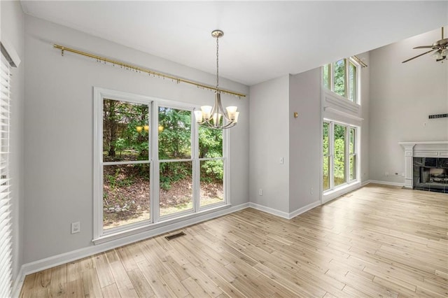 600 Oakmont Hl, Duluth, GA 30097 - unfurnished dining area with a chandelier, plenty of natural light, wood finished floors, and a high end fireplace