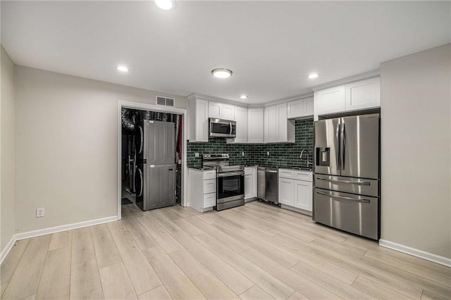 600 Oakmont Hl, Duluth, GA 30097 - kitchen with stainless steel appliances, light wood-style floors, white cabinetry, decorative backsplash, and recessed lighting