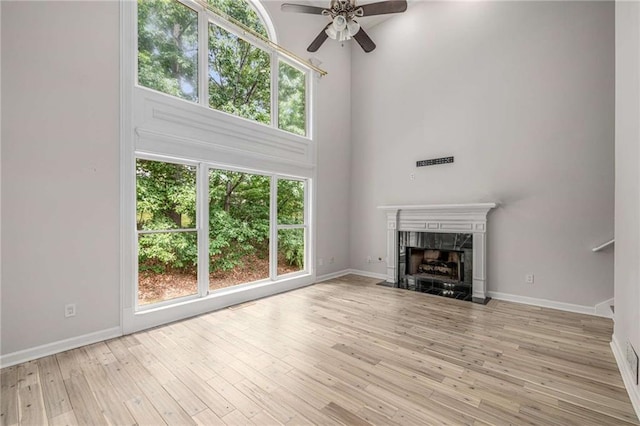 600 Oakmont Hl, Duluth, GA 30097 - unfurnished living room with ceiling fan, a towering ceiling, a fireplace, wood finished floors, and stairs