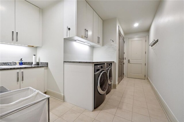 laundry room with cabinets, sink, separate washer and dryer, and light tile patterned flooring