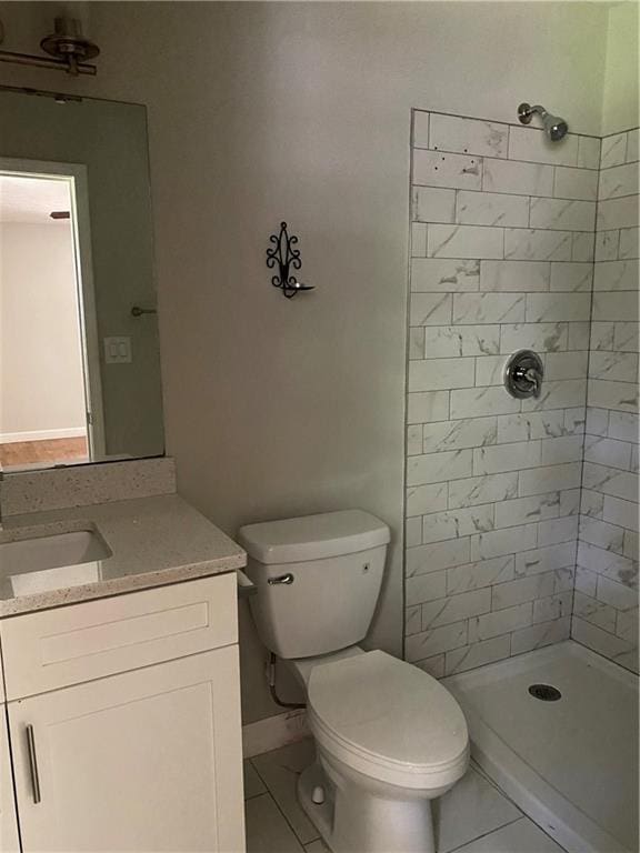 bathroom with vanity, a tile shower, and toilet