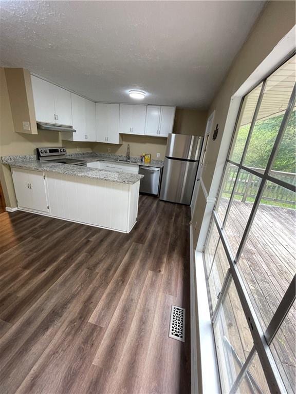 6399 Boca Grande Blvd, Forest Park, GA 30297 - kitchen with appliances with stainless steel finishes, under cabinet range hood, dark wood finished floors, white cabinetry, and a textured ceiling