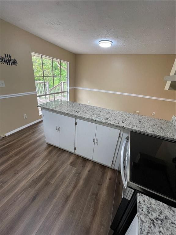 6399 Boca Grande Blvd, Forest Park, GA 30297 - kitchen with a textured ceiling, stainless steel microwave, dark wood-style floors, white cabinets, and baseboards