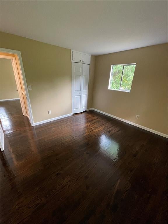 6399 Boca Grande Blvd, Forest Park, GA 30297 - unfurnished bedroom featuring baseboards, dark wood-style flooring, and a closet