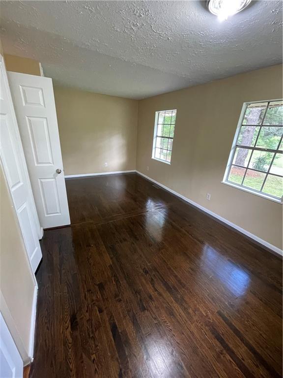 6399 Boca Grande Blvd, Forest Park, GA 30297 - spare room featuring a textured ceiling, wood finished floors, and baseboards