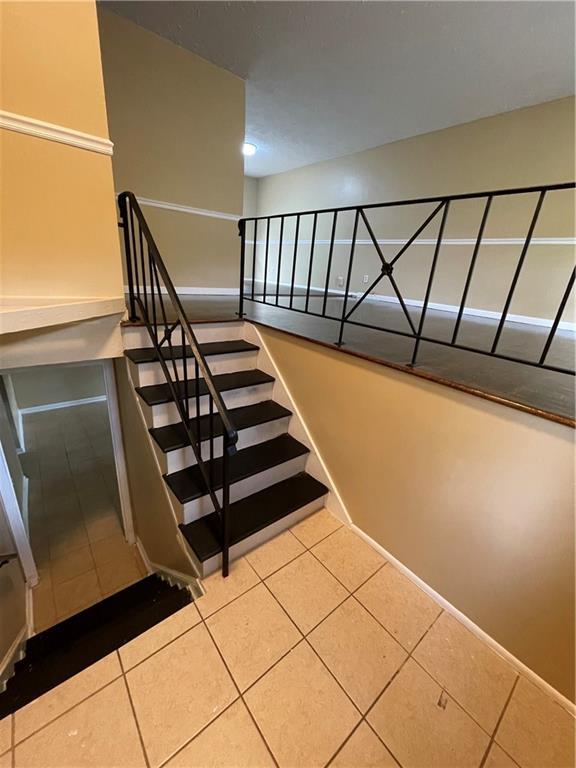 6399 Boca Grande Blvd, Forest Park, GA 30297 - staircase featuring tile patterned floors and baseboards