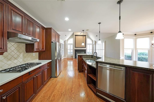 kitchen featuring a wealth of natural light, stainless steel appliances, hanging light fixtures, and sink