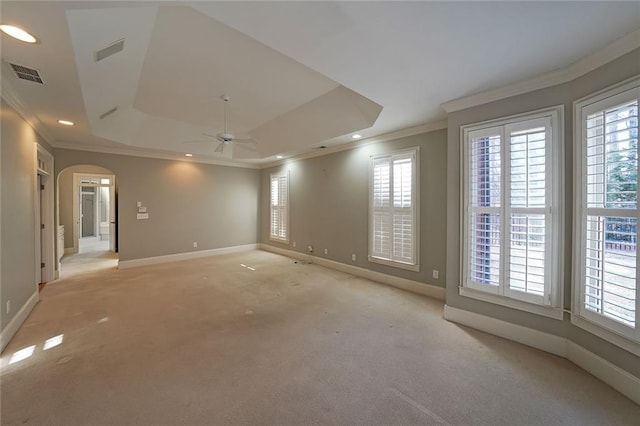 carpeted empty room featuring ceiling fan, ornamental molding, and a raised ceiling