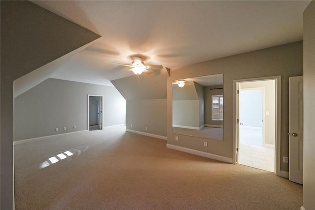 additional living space featuring ceiling fan, lofted ceiling, and light colored carpet