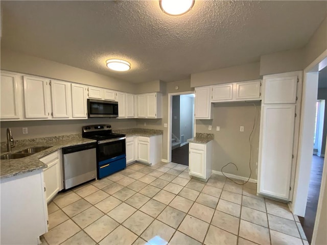 kitchen featuring white cabinets, appliances with stainless steel finishes, sink, and light stone counters