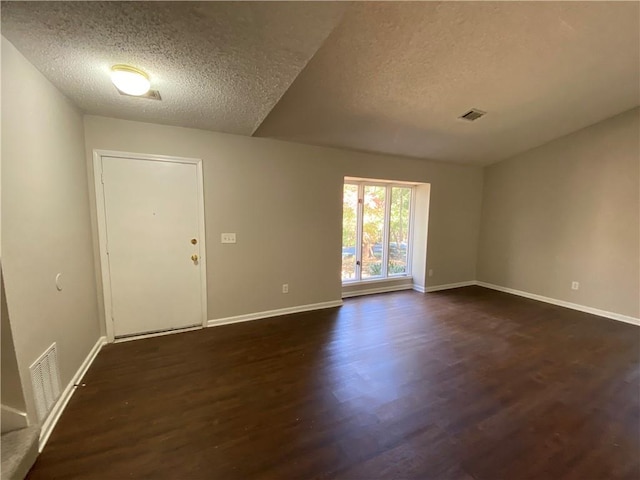 empty room featuring dark hardwood / wood-style flooring and a textured ceiling