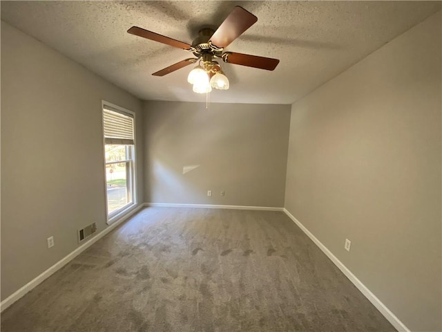 carpeted empty room with ceiling fan and a textured ceiling