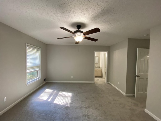 interior space with ceiling fan, light colored carpet, and a textured ceiling