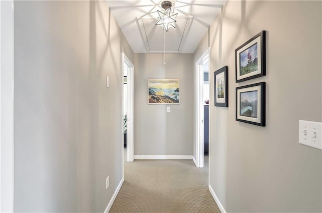 hall with light carpet, a wealth of natural light, attic access, and baseboards