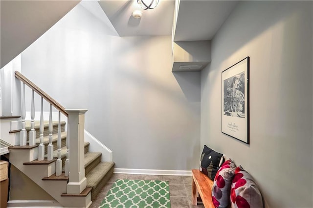 stairs featuring tile patterned flooring and baseboards