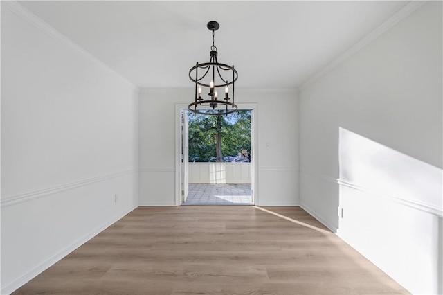 unfurnished dining area with crown molding, light hardwood / wood-style floors, and a notable chandelier