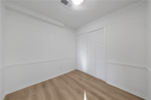 unfurnished bedroom featuring light hardwood / wood-style floors and a closet