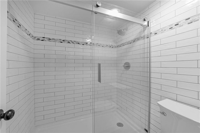 bathroom featuring an enclosed shower and toilet