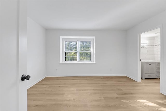 empty room with sink and light hardwood / wood-style flooring