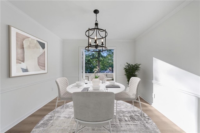 dining room with hardwood / wood-style flooring, crown molding, and a notable chandelier