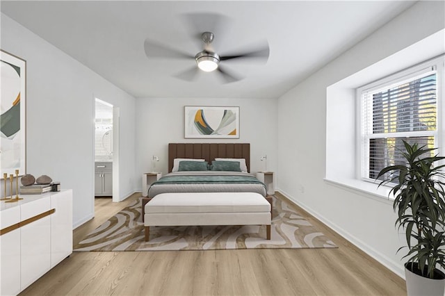 bedroom with ceiling fan, ensuite bathroom, and light hardwood / wood-style floors