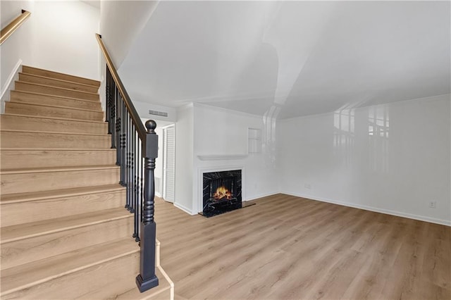 unfurnished living room with wood-type flooring and a high end fireplace