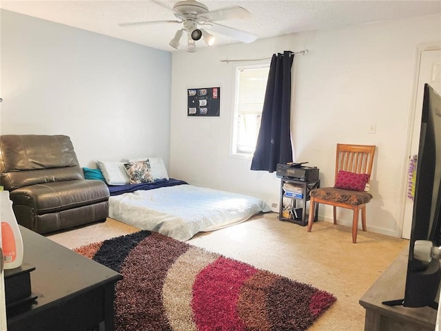 bedroom with ceiling fan, carpet, and a textured ceiling