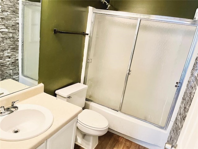 full bathroom with toilet, vanity, enclosed tub / shower combo, and hardwood / wood-style flooring