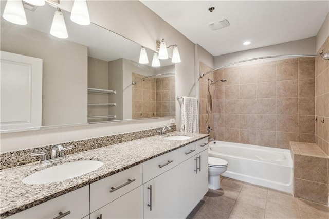 full bathroom with tiled shower / bath, vanity, and toilet